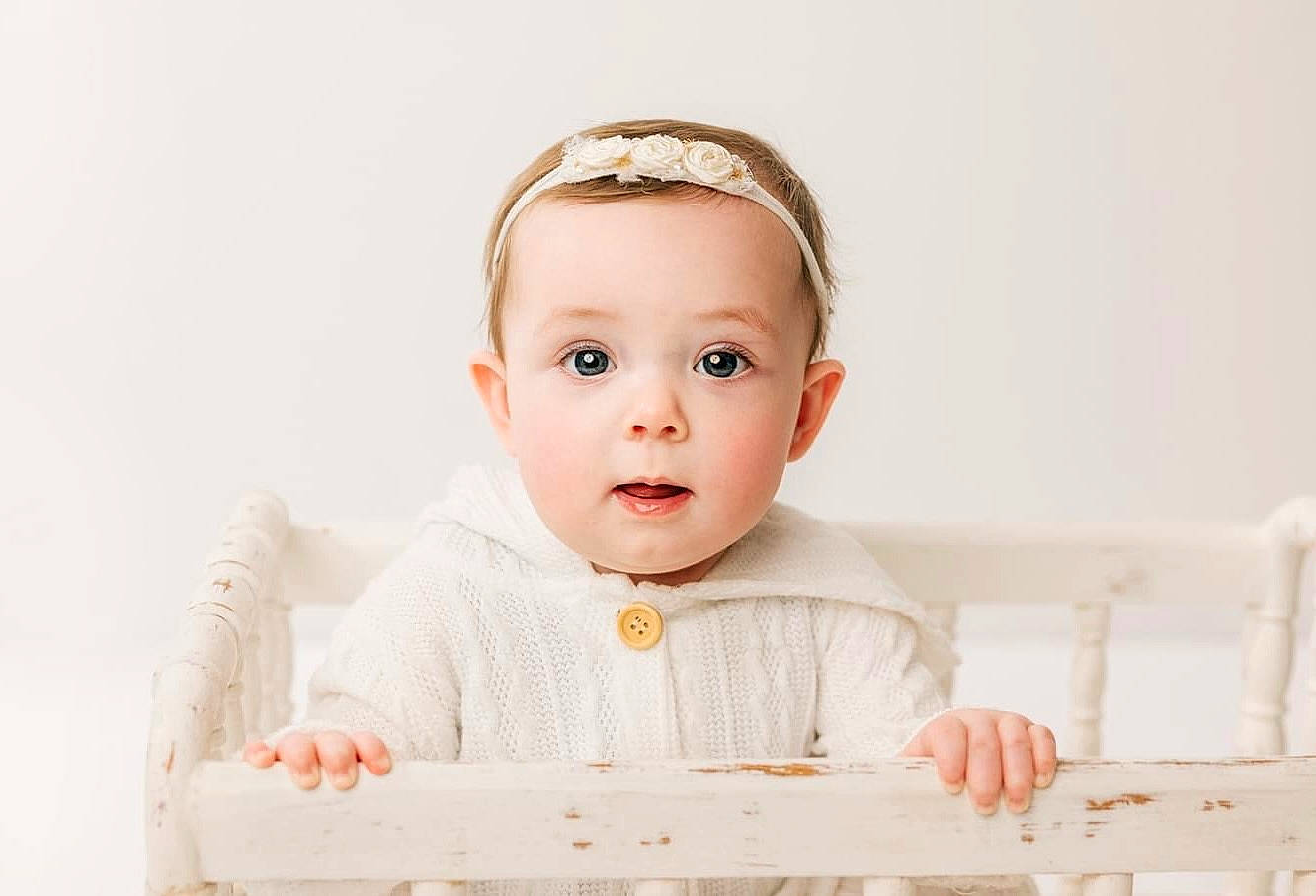 Emma is registered to the contest to win money with this photo: baby, baby_toddler_clothing, cheek, collar, comfort, dress, dress_shirt, ear, eyelash, fashion_accessory, flash_photography, happy, linens, pattern, person, portrait_photography, rectangle, sitting, sleeve, surprise