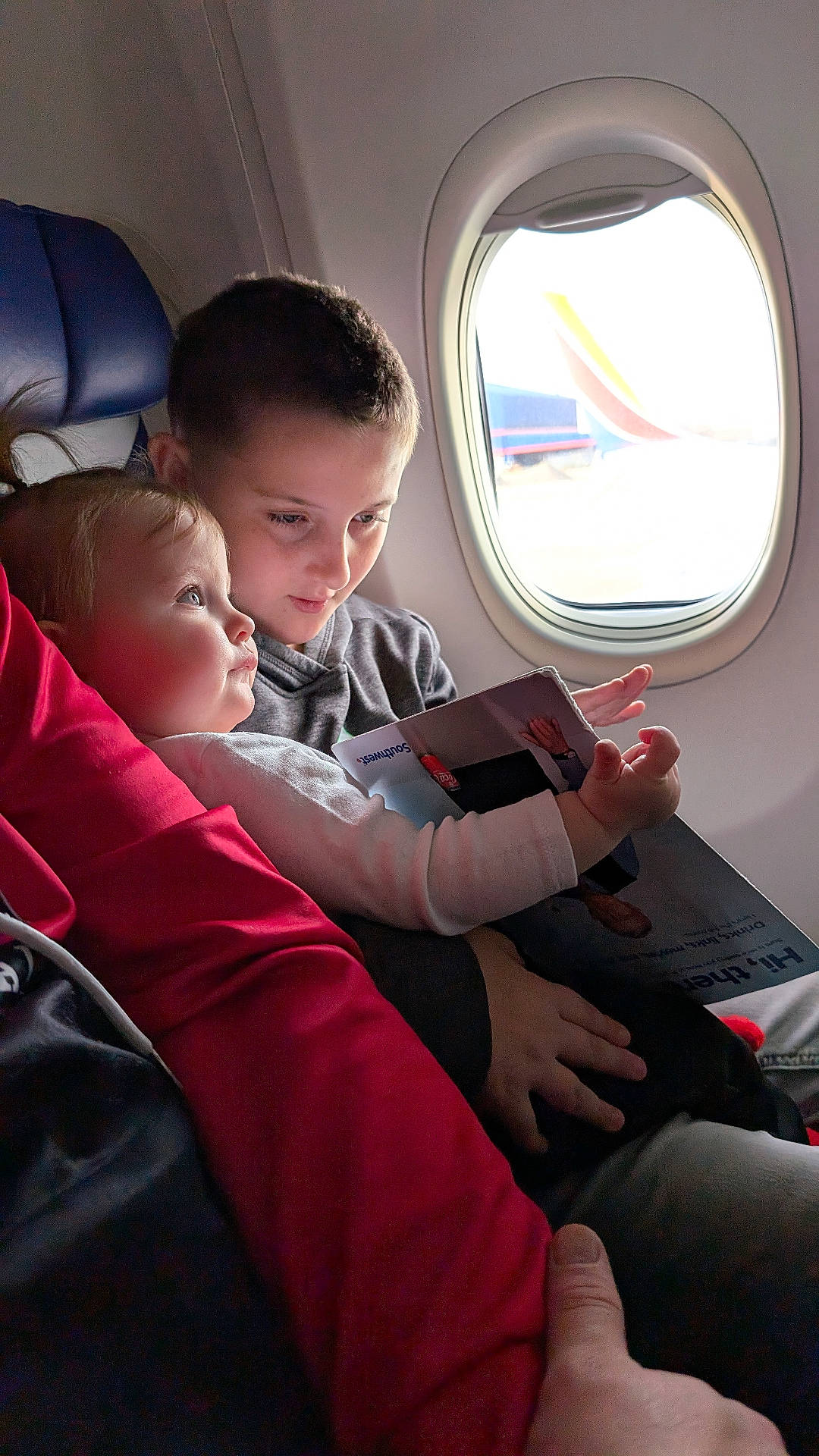 aircraft, baby, bodypart, boy, child, couch, cushion, face, finger, furniture, hand, head, homedecor, male, person, photography, porthole, transportation, vehicle, window