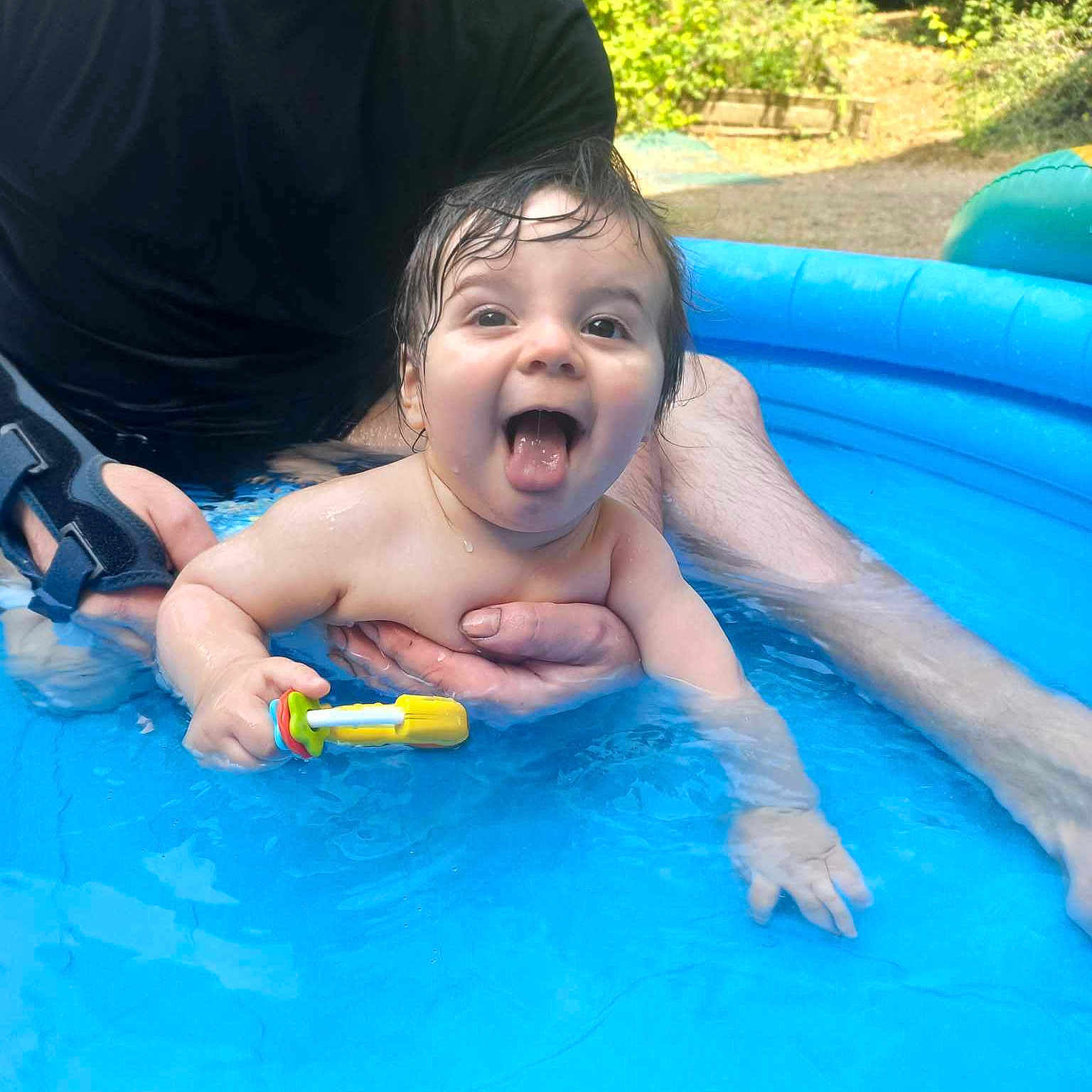 Eiji participe au concours pour gagner de l'argent avec cette photo : adult, baby, child, fun, garden, greenery, hand, happy, outdoor, person, play, pool, smile, splash, summer, sunlight, tongue, toy, water, wrist_brace