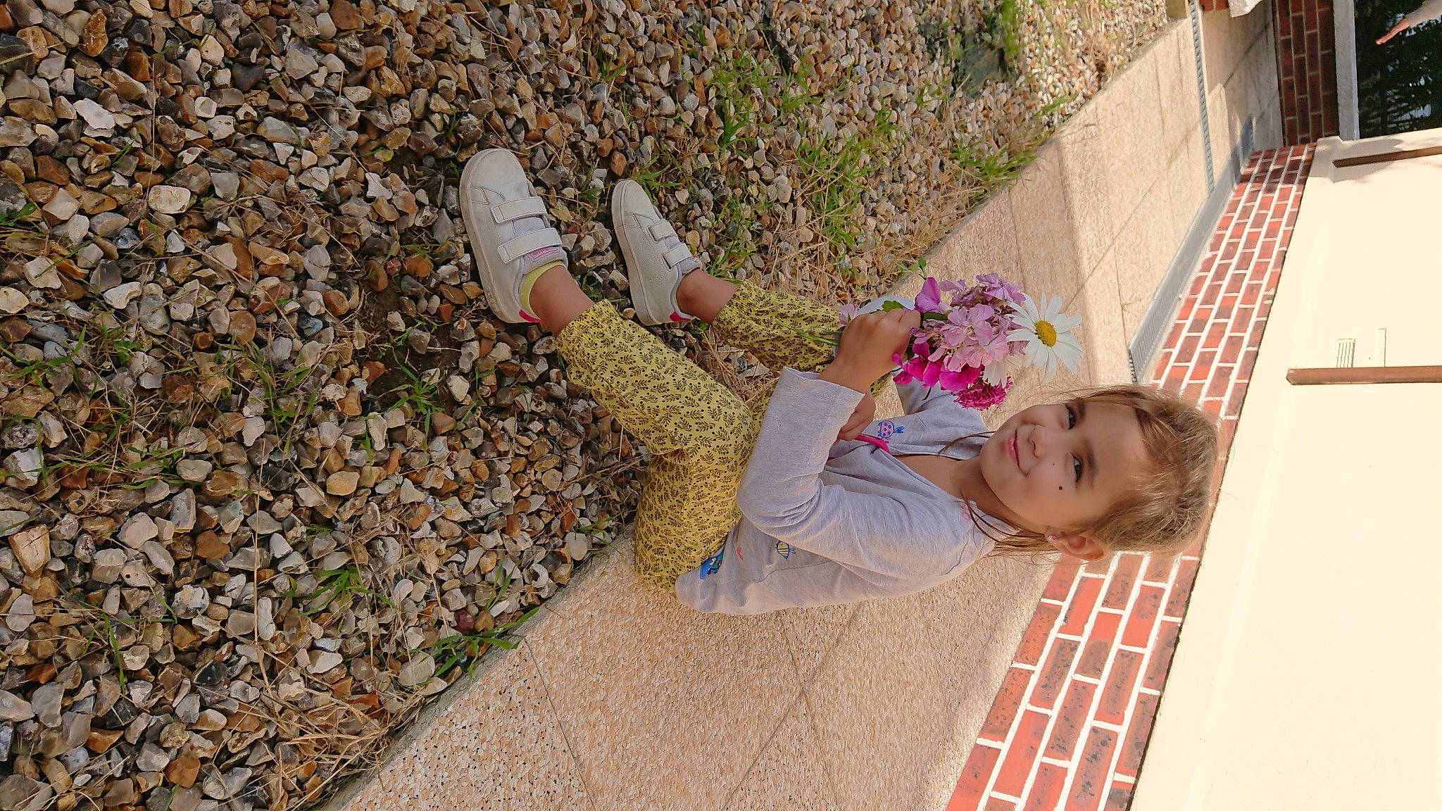 Timea a rejoint le concours — aidez-le/la à gagner de superbes lots ! asphalt, eyewear, flooring, flower, foot, grass, human_leg, joy, leisure, magenta, pattern, people_in_nature, person, plant, road_surface, sidewalk, sitting, smile, soil, street_fashion