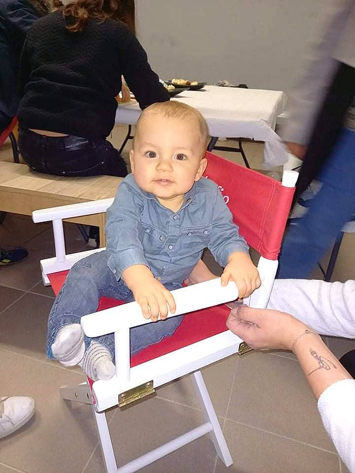Thilio participe au concours pour gagner de l'argent avec cette photo : baby_toddler_clothing, carmine, chair, child, comfort, electric_blue, event, flooring, fun, human_leg, joint, knee, lap, leisure, person, room, sitting, standing, thigh, toddler
