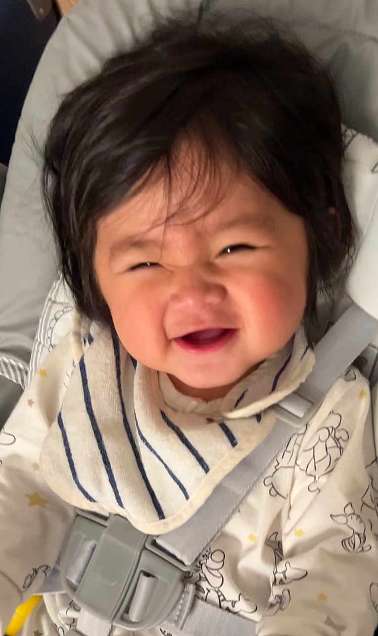 Leilan a rejoint le concours — aidez-le/la à gagner de superbes lots ! baby, child, smiling, happy, car_seat, seatbelt, bib, clothing, infant, face, hair, cute, patterned_clothing, indoors, closeup, strapped, toddler, person, cheerful, expression