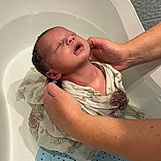 Biliie participe au concours pour gagner de l'argent avec cette photo : baby, infant, bath, water, hands, cloth, wrapped, tub, skin, head, expression, person, care, support, newborn, wet, bathroom, comfort, closeup, parent