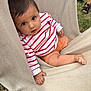 Biliie a rejoint le concours — aidez-le/la à gagner de superbes lots ! toddler, child, baby, striped_sweater, orange_shorts, hammock, outdoor, grass, barefoot, hand, face, curious, seated, person, summer, feet, fabric, texture, casual_clothing, daylight