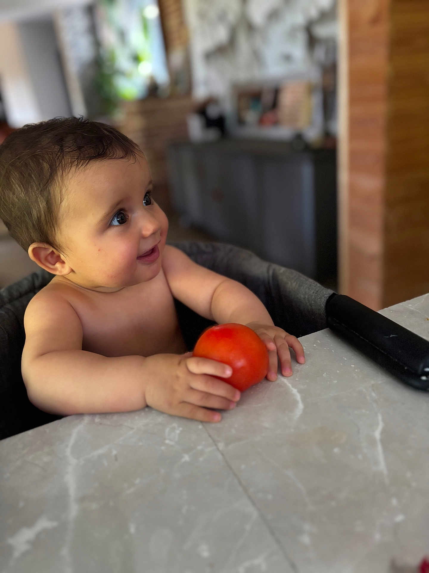 Biliie a rejoint le concours — aidez-le/la à gagner de superbes lots ! baby, child, tomato, high_chair, table, indoor, person, food, curious, smiling, skin, face, hand, furniture, kitchen, blurred_background, young_child, sitting, cute, happy