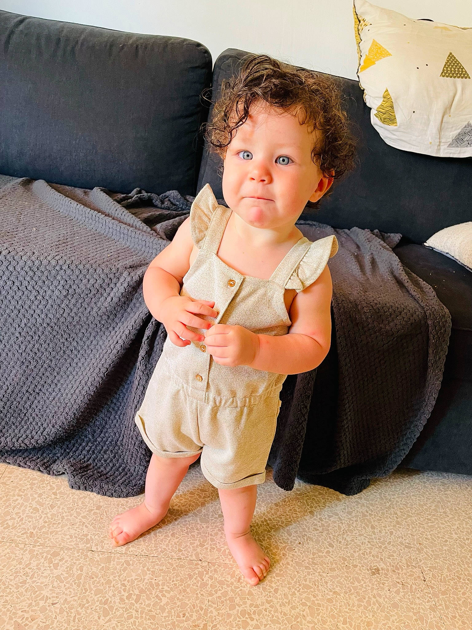 Hilona participe au concours pour gagner de l'argent avec cette photo : baby_toddler_clothing, barefoot, child, comfort, couch, elbow, finger, flooring, foot, gesture, happy, human_leg, knee, leg, linens, person, sitting, sleeve, thigh, thumb