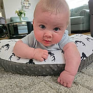 Michael is registered to the contest to win money with this photo: baby, infant, child, cushion, carpet, indoor, living_room, arm, face, eyes, curious, cute, soft, blanket, furniture, home, floor, skin, clothing, person