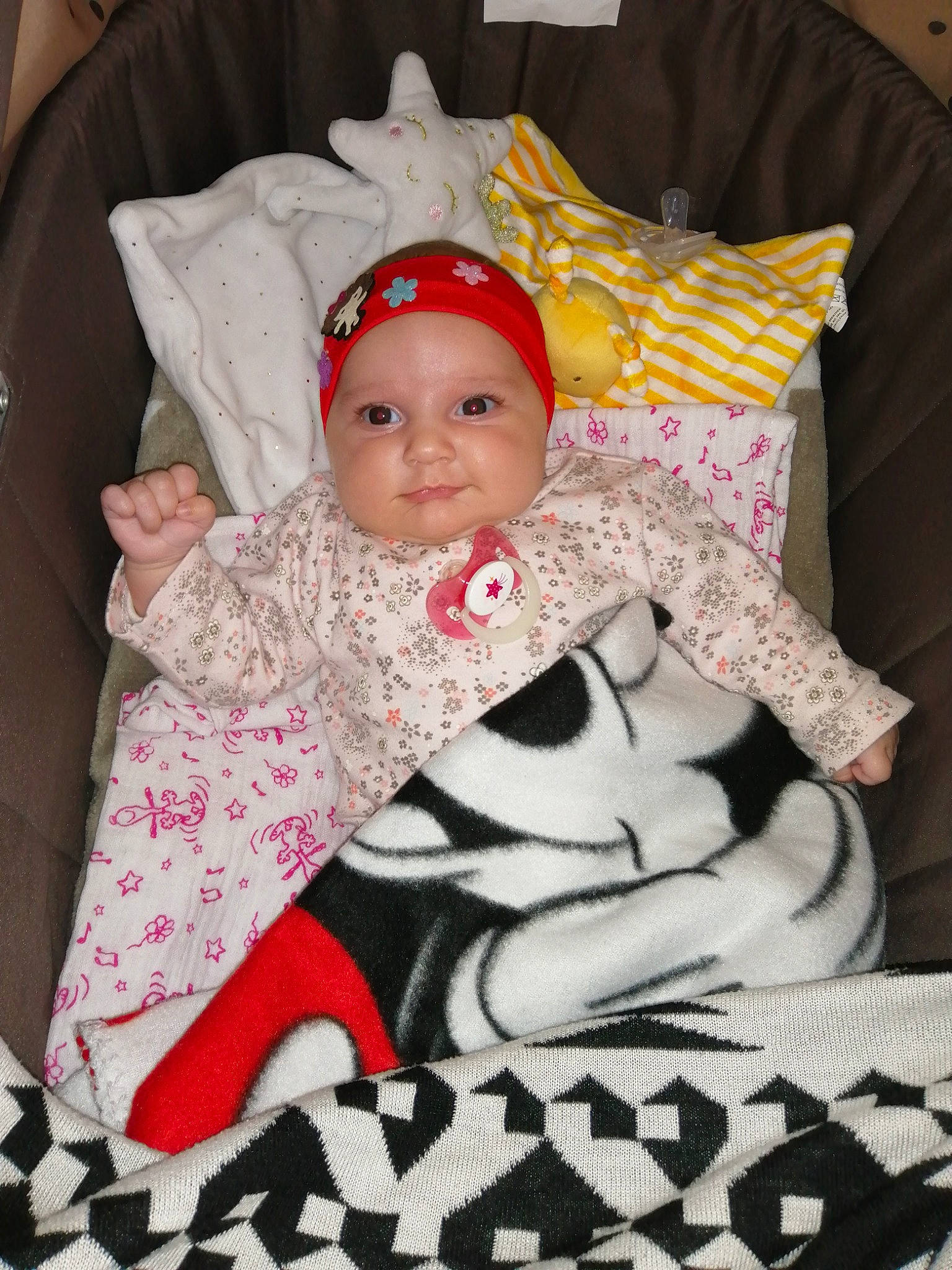 Ynes participe au concours pour gagner de l'argent avec cette photo : baby, baby_carriage, baby_products, baby_toddler_clothing, child, comfort, event, face, fashion_accessory, headwear, lap, linens, mammal, pattern, person, pink, room, sitting, sleeve, smile