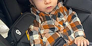 Thélio a rejoint le concours — aidez-le/la à gagner de superbes lots ! baby, black_cushion, buttoned_shirt, casual_clothing, child, curious, cute, face, green_bottle_holder, hands, indoor, infant, orange_booties, plaid_shirt, portrait, seat_belt, seated, stroller, wide_eyes, young_child