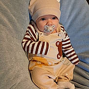 Dakoda joined the competition — help win amazing prizes! baby, blanket, child, clothing, cute, eyes, face, feet, hands, hat, indoor, infant, overalls, pacifier, portrait, resting, sleepwear, socks, soft_toys, striped_shirt