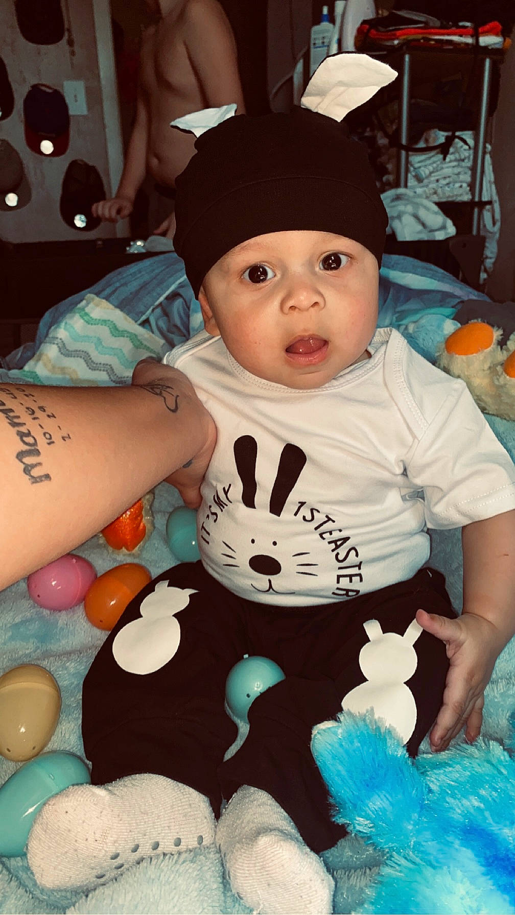 Kane is registered to the contest to win money with this photo: baby, baby_products, baby_toddler_clothing, blue, cap, child, comfort, cool, fun, happy, headwear, human, human_leg, pattern, person, sitting, skin, sleeve, surprise, t_shirt