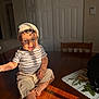 Daniel is registered to the contest to win money with this photo: baby, barefoot, beige_pants, blue_eyes, child, curly_hair, cute, door, furniture, hat, indoor, person, playful, portrait, shadow, smile, striped_shirt, sunlight, toddler, wooden_table