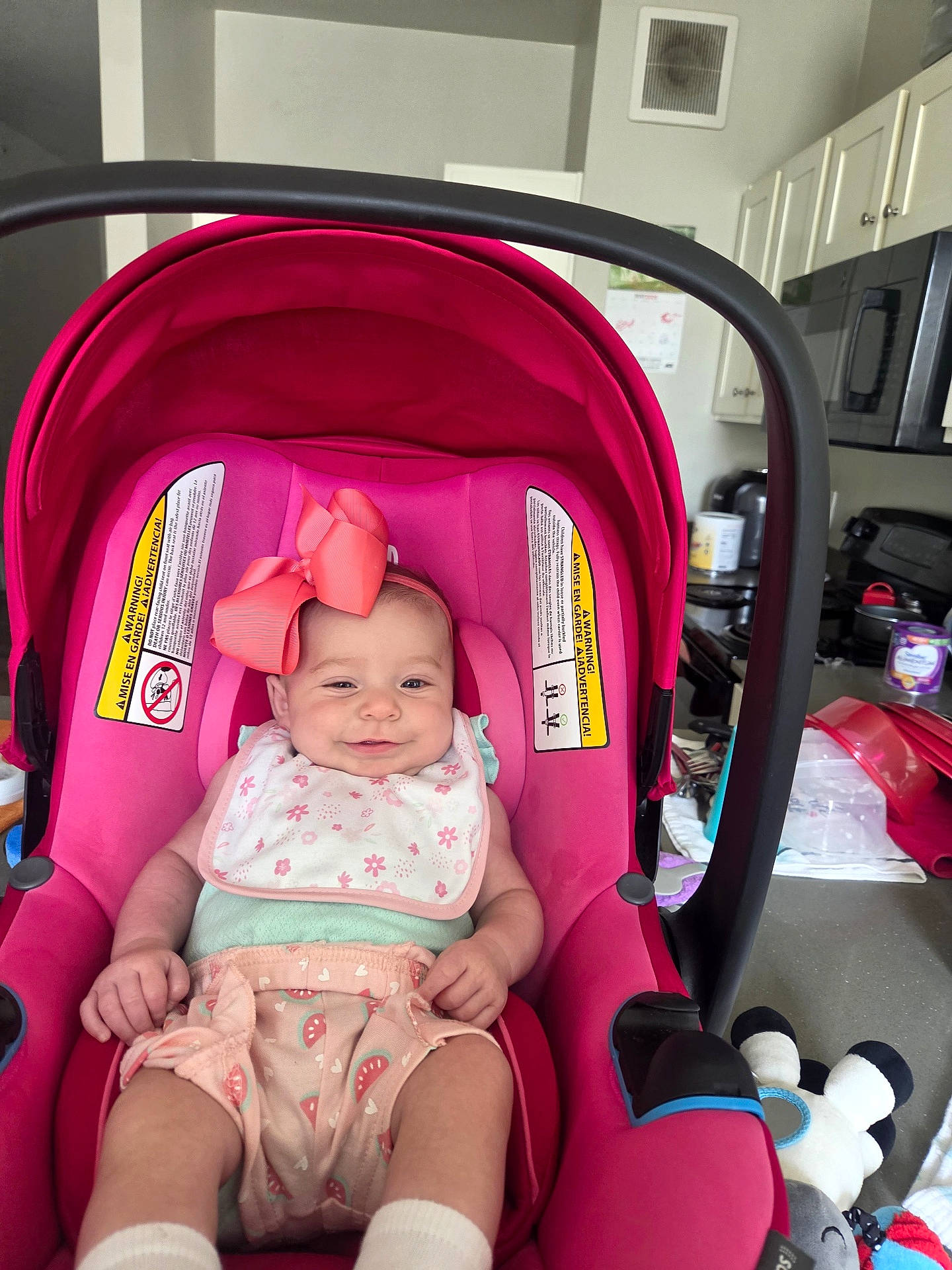 Emily joined the competition — help win amazing prizes! appliance, baby, bib, bow, cabinet, car_seat, child, clothing, countertop, cute, happy, headwear, indoor, infant, kitchen, person, pink, seat, smile, toy