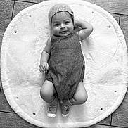 Jacques Isaac participe au concours pour gagner de l'argent avec cette photo : baby, infant, smile, knit_cap, onesie, socks, fluffy_mat, floor, wooden_floor, black_and_white, portrait, child, cute, happy, relaxed, lying_down, indoor, cozy, soft_texture, headwear