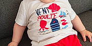 Swan participe au concours pour gagner de l'argent avec cette photo : apparel, baby, casual, child, clothing, couch, cute, face, happy, hat, headwear, indoor, infant, person, playful, red_shorts, shorts, sitting, smiling, tshirt