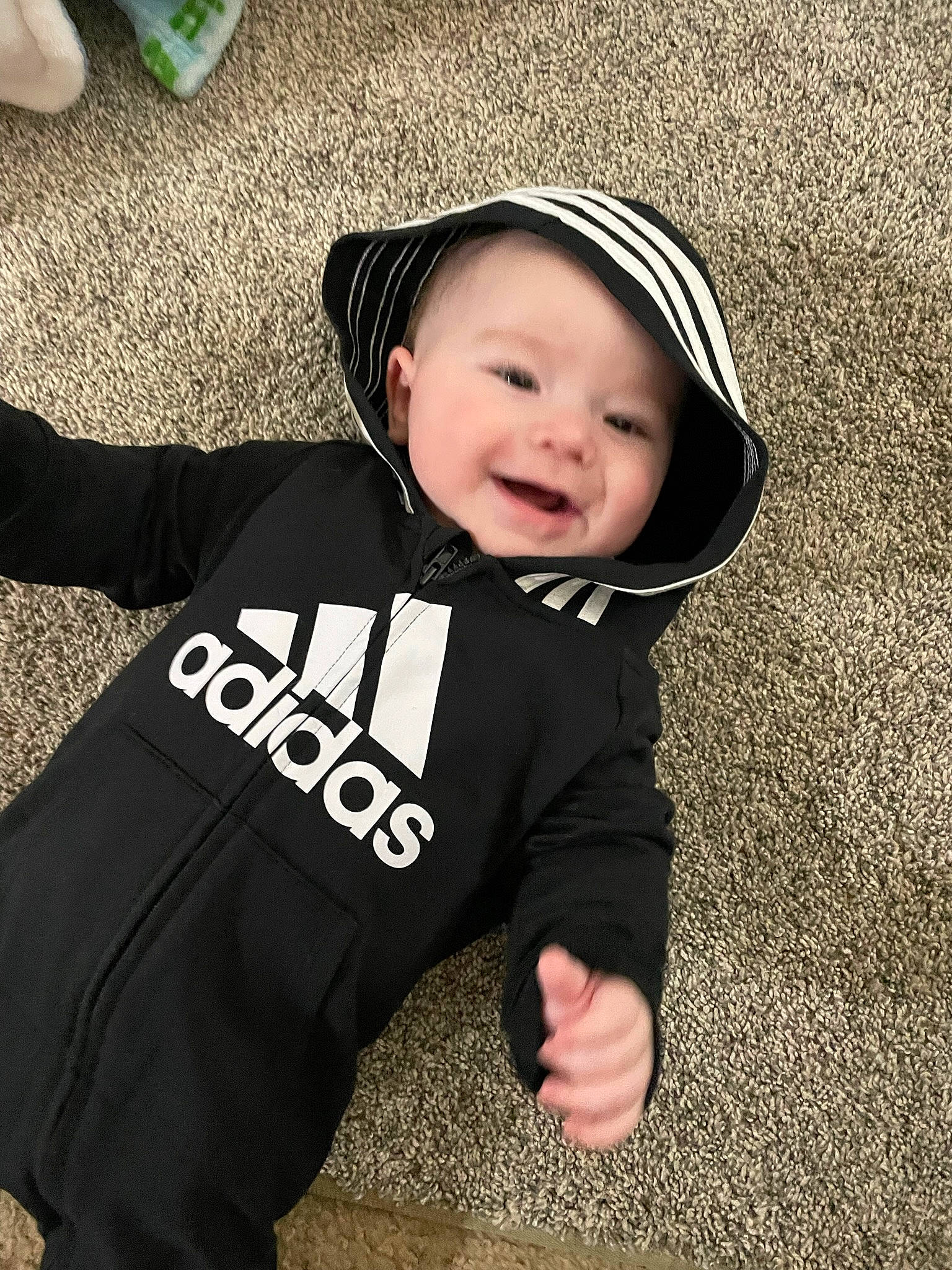 Korbin is registered to the contest to win money with this photo: asphalt, baby, baby_toddler_clothing, cap, child, cool, fashion_accessory, flash_photography, fun, gesture, grass, green, happy, hat, headwear, outerwear, person, sitting, sleeve, smile