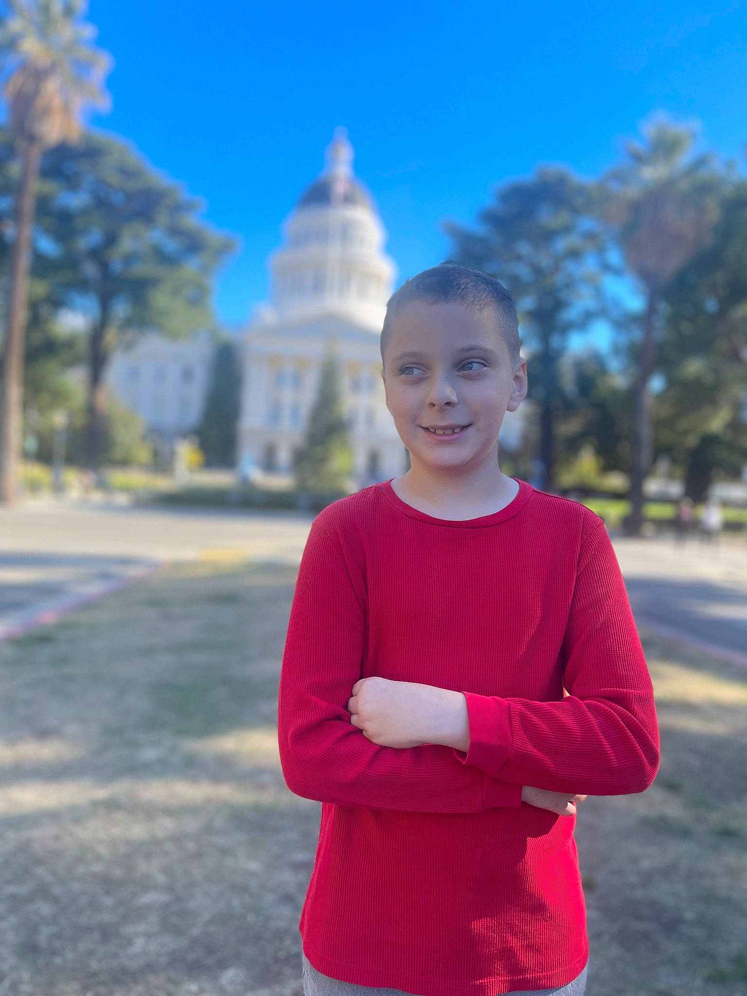 Nate is registered to the contest to win money with this photo: child, city, electric_blue, eye, fun, grass, happy, head, joy, leisure, magenta, person, plant, recreation, sky, sleeve, smile, t_shirt, toddler, tower