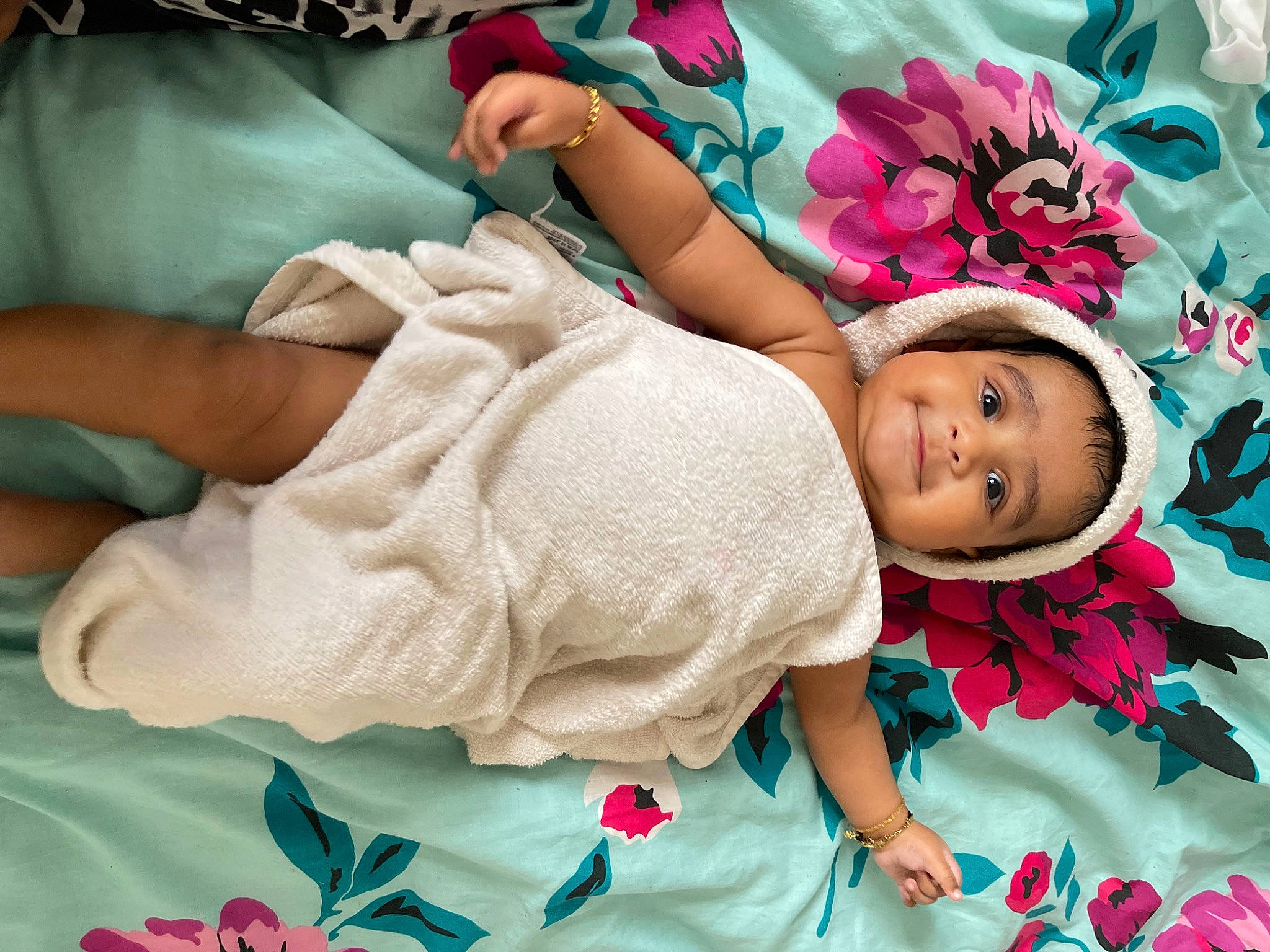 Varun is registered to the contest to win money with this photo: baby, baby_toddler_clothing, bedding, child, comfort, fashion_accessory, green, happy, joy, leisure, linens, magenta, pattern, person, petal, pink, room, skin, sleeve, smile