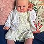 baby, infant, bed, pillow, clothing, cardigan, white, soft, cute, face, legs, socks, bunny_pattern, hand, blue_eyes, blanket, floral, comfort, indoor, portrait