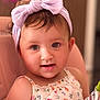 Angelina is registered to the contest to win money with this photo: toddler, child, baby, headband, bow, floral_dress, high_chair, snack_pouch, indoor, cute, face, smile, person, skin, hair, seat, food, young_child, portrait, happy