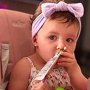 Angelina joined the competition — help win amazing prizes! toddler, child, baby, headband, bow, high_chair, snack_pouch, feeding, indoor, cute, pink, clothing, person, face, hand, tableware, spoon, hair, earrings, expression