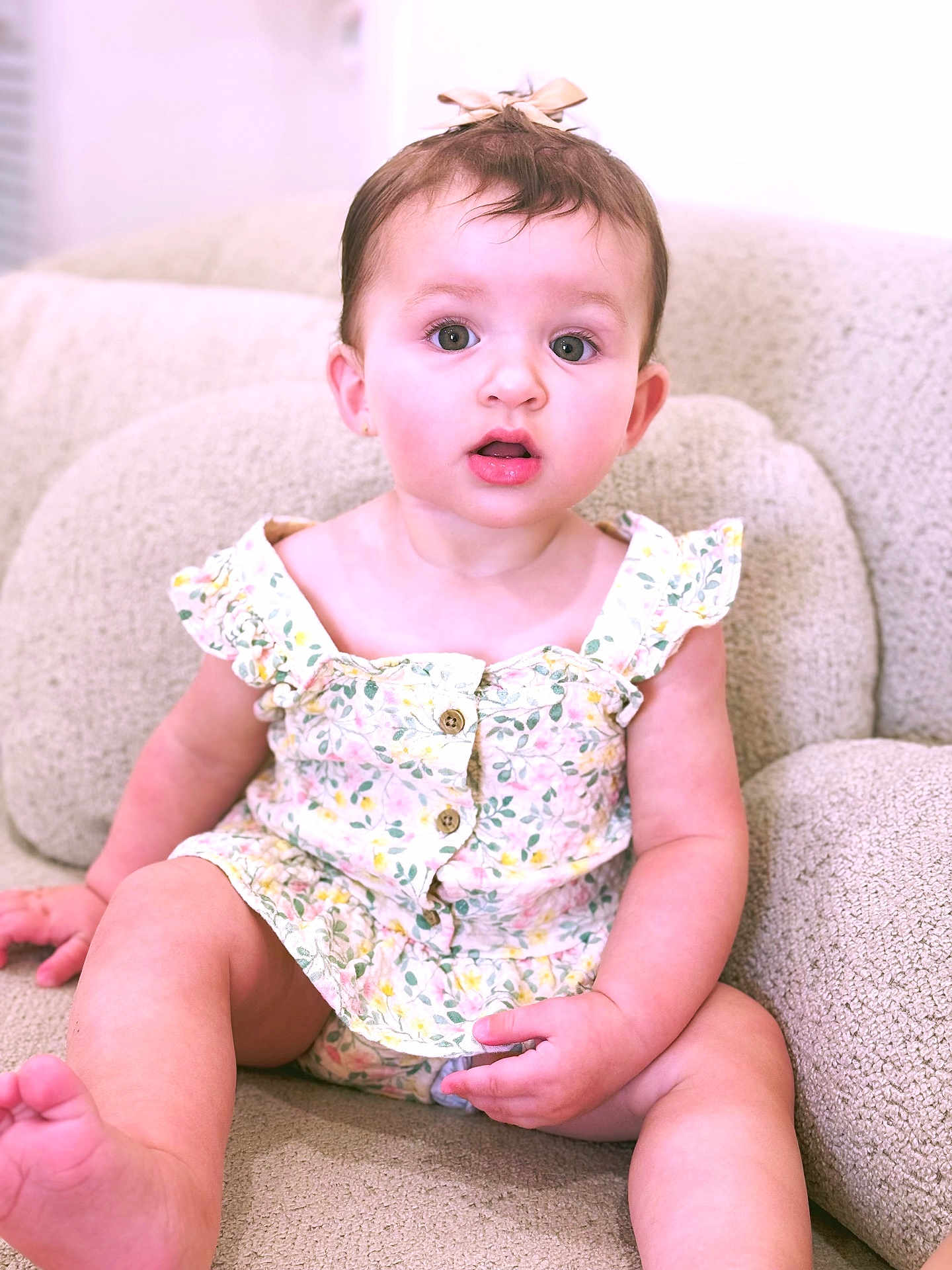 Angelina joined the competition — help win amazing prizes! baby, child, girl, sitting, couch, floral_dress, bow, curly_hair, cute, indoors, portrait, child_fashion, furniture, expression, skin, legs, hands, eyes, face, comfort