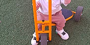 Liam participe au concours pour gagner de l'argent avec cette photo : child, daylight, fun, green_turf, happy, orange, outdoor, person, pink_pants, play, playground, recreation, red_cone, smiling, sneakers, toddler, toy, tricycle, white_shirt, young_child