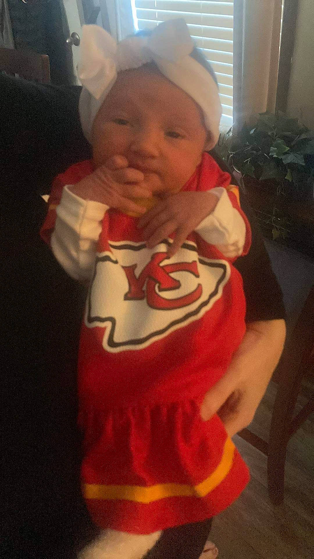 Olivia Rae is registered to the contest to win money with this photo: baby, baby_toddler_clothing, cap, cheek, chest, child, fictional_character, fun, happy, head, houseplant, mouth, person, personal_protective_equipment, plant, selfie, sleeve, sportswear, t_shirt, thumb