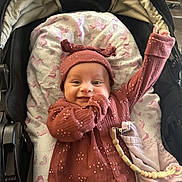 Freya joined the competition — help win amazing prizes! baby, infant, smile, stroller, blanket, hat, clothing, cute, happy, child, portrait, indoors, fabric, toy, pacifier, accessory, pink, maroon, pattern, cozy