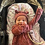 baby, infant, smile, stroller, blanket, hat, clothing, cute, happy, child, portrait, indoors, fabric, toy, pacifier, accessory, pink, maroon, pattern, cozy