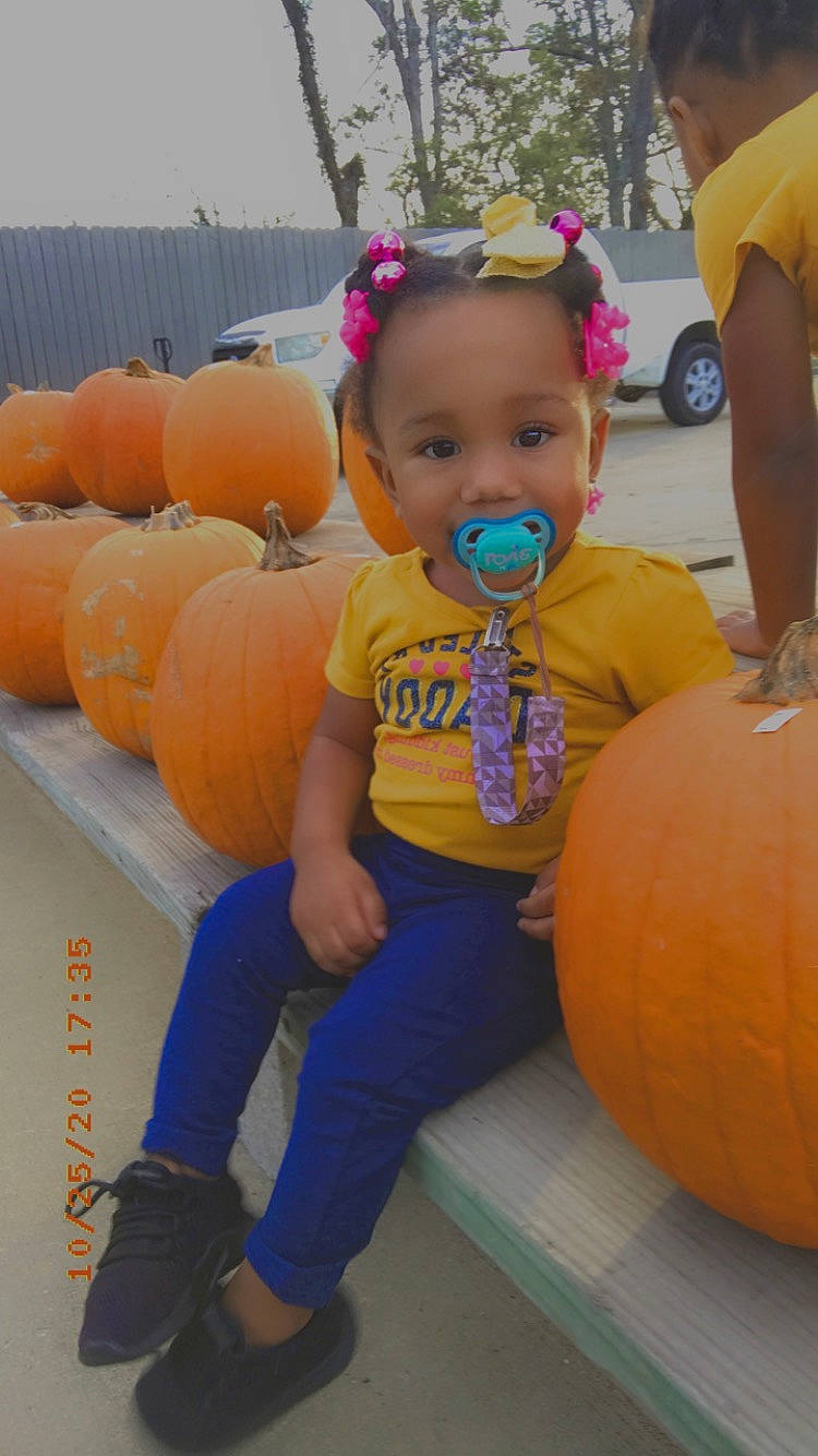 Lauryn is registered to the contest to win money with this photo: arm, calabaza, clothing, cucurbita, facial_expression, fruit, fun, gourd, local_food, natural_foods, orange, person, plant, pumpkin, squash, t_shirt, toddler, tree, vegetable, wheel