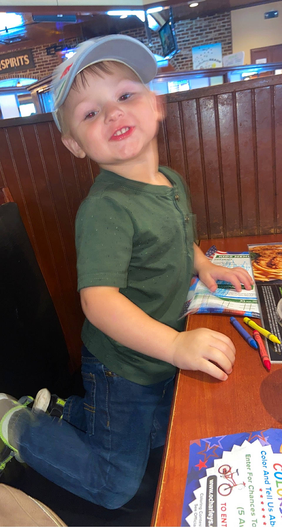 Wesson is registered to the contest to win money with this photo: baseball_cap, blue, cap, chair, child, desk, electric_blue, finger, fun, hat, jeans, lap, leisure, person, play, smile, standing, t_shirt, table, thigh