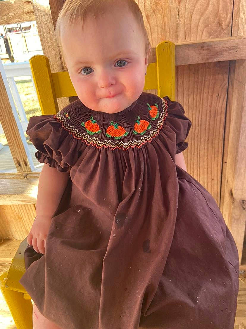 Emerson is registered to the contest to win money with this photo: baby, baby_toddler_clothing, cheek, day_dress, dress, face, formal_wear, happy, head, iris, magenta, one_piece_garment, orange, outerwear, pattern, person, pink, sleeve, toddler, trunk