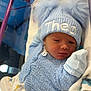 Theo is registered to the contest to win money with this photo: newborn, baby, infant, blue_hat, knitted_sweater, crib, plush_toy, blanket, sleepy, cute, soft_toys, baby_clothes, mittens, portrait, indoors, resting, cozy, child, person, baby_boy