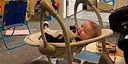 Theo joined the competition — help win amazing prizes! baby, baby_rocker, smile, indoor, carpet, foam_play_mat, toys, chair, storage_boxes, door, wall, floor, happy, child, person, furniture, room, playtime, infant, relaxing