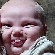Jaxson is registered to the contest to win money with this photo: baby, face, tongue, cheeks, skin, arm, shirt, expression, child, person, head, cute, smile, funny_face, indoors, closeup, human, infant, playful, chubby