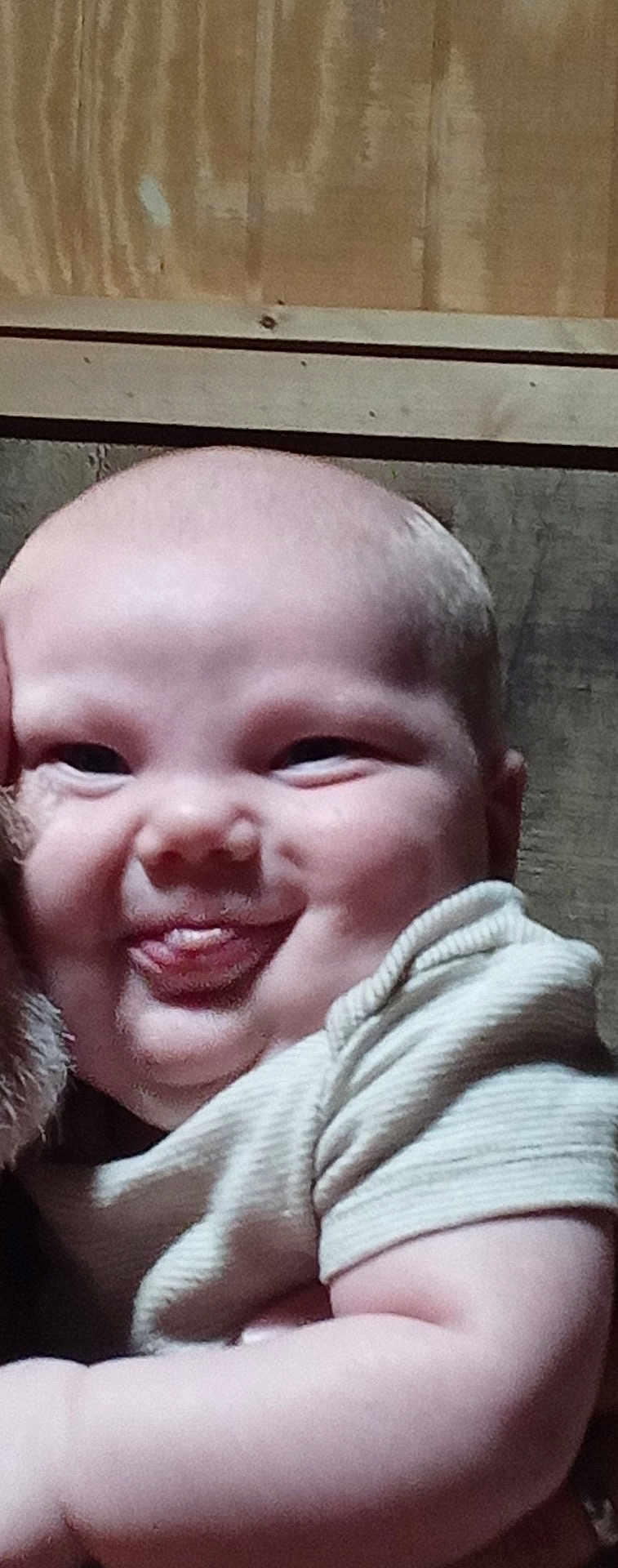 Jaxson is registered to the contest to win money with this photo: baby, face, tongue, cheeks, skin, arm, shirt, expression, child, person, head, cute, smile, funny_face, indoors, closeup, human, infant, playful, chubby