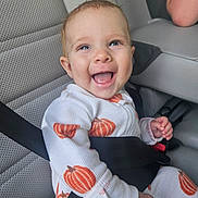 Juniper joined the competition — help win amazing prizes! baby, child, car_seat, seatbelt, smile, happy, pumpkin_pattern, clothing, infant, cute, car_interior, sitting, safety, young_child, person, portrait, joyful, cute_outfit, seat, baby_clothes