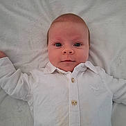 Loën participe au concours pour gagner de l'argent avec cette photo : baby, infant, child, face, eyes, white_shirt, buttons, collar, blanket, bedding, lying_down, portrait, looking_at_camera, cute, newborn, skin, hands, bed, closeup, smile