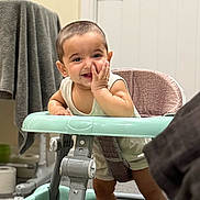 Jujhar is registered to the contest to win money with this photo: baby, walker, smiling, indoor, child, furniture, towel, toilet_paper, carpet, door, hand, clothing, face, happy, person, floor, seat, head, expression, home
