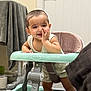 baby, walker, smiling, indoor, child, furniture, towel, toilet_paper, carpet, door, hand, clothing, face, happy, person, floor, seat, head, expression, home