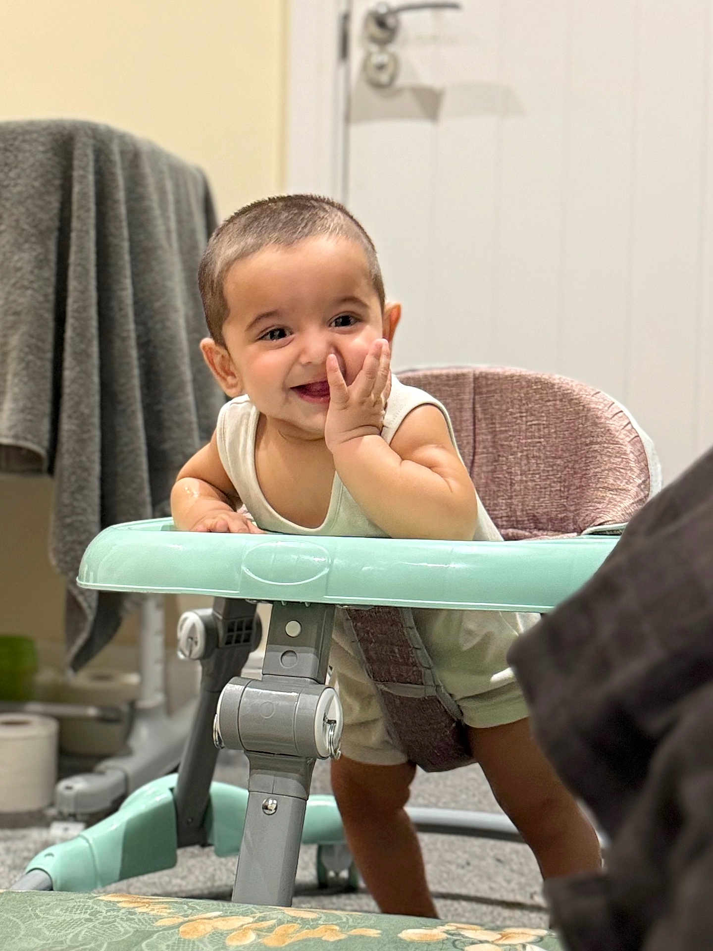 Jujhar is registered to the contest to win money with this photo: baby, walker, smiling, indoor, child, furniture, towel, toilet_paper, carpet, door, hand, clothing, face, happy, person, floor, seat, head, expression, home