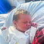 newborn, baby, sleeping, onesie, giraffe, stars, soft_light, blanket, indoor, cute, infant, clothing, face, peaceful, child, portrait, resting, plaid, red, cozy