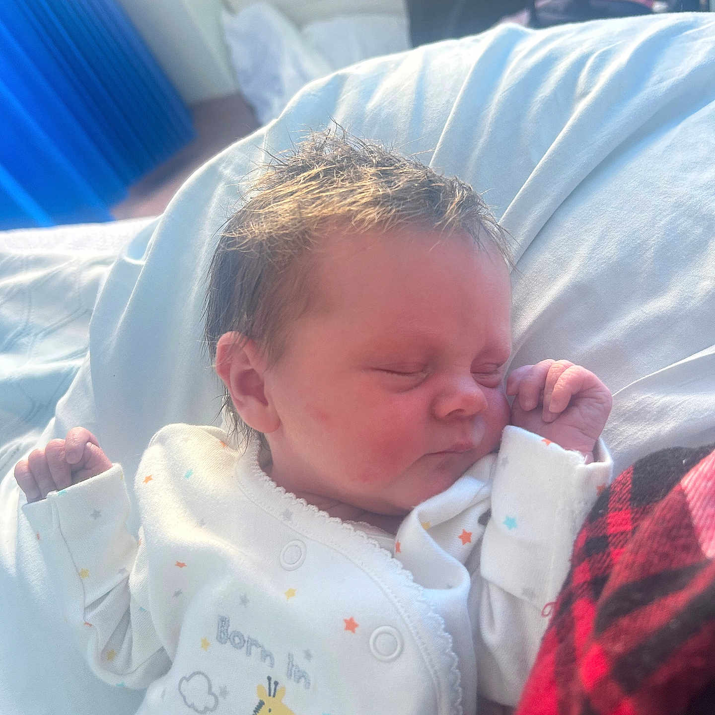 Robyn is registered to the contest to win money with this photo: baby, blanket, child, clothing, cozy, cute, face, giraffe, indoor, infant, newborn, onesie, peaceful, plaid, portrait, red, resting, sleeping, soft_light, stars