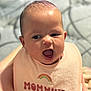 Dahlilah joined the competition — help win amazing prizes! baby, infant, bib, face, expression, open_mouth, skin, person, cute, child, close_up, pink, rainbow, text_on_clothing, head, soft_light, indoors, human, young, apparel