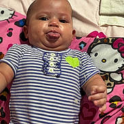 Dahlilah joined the competition — help win amazing prizes! baby, tongue, striped_onesie, green_heart, hello_kitty, blanket, lying_down, cute, playful, infant, child, pink, patterned, clothing, portrait, hand, face, expression, indoor, soft_toy