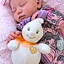 baby, sleeping, plush_toy, blanket, headband, onesie, purple, pink, child, infant, soft_texture, cute, peaceful, hand, face, smile, toy, cozy, portrait, resting