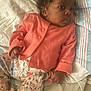 baby, infant, child, coral_cardigan, floral_pants, pacifier, blanket, soft_toys, lying_down, curly_hair, indoors, cute, sleepwear, newborn, hand, footwear, resting, portrait, calm, cozy