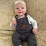 Hunter joined the competition — help win amazing prizes! baby, child, infant, sitting, couch, overalls, white_socks, face, blue_eyes, patterned_fabric, furniture, indoor, portrait, cute, smiling, young_child, clothing, person, home, relaxed