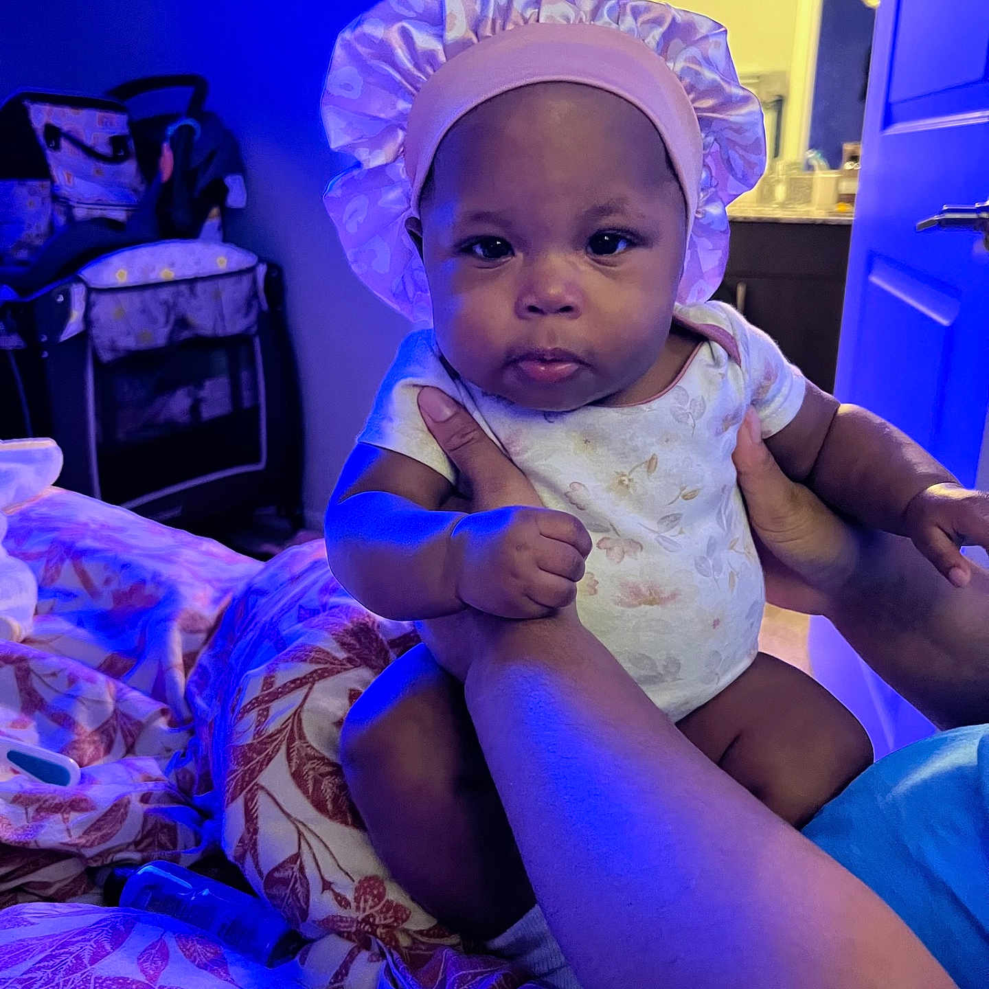 Kameron joined the competition — help win amazing prizes! baby, bed, bedroom, bodypart, bonnet, cap, clothing, couch, dress, face, furniture, hat, head, indoors, person, photography, portrait, purple, room, sitting